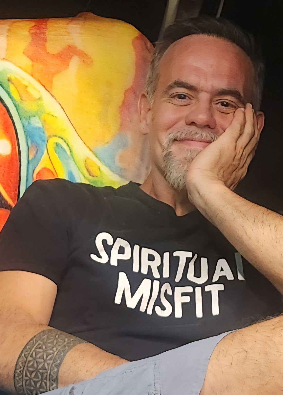 Portrait of a man in his early fifties wearing a black t-shirt, relaxed and smiling, embodying calm confidence and resilience.