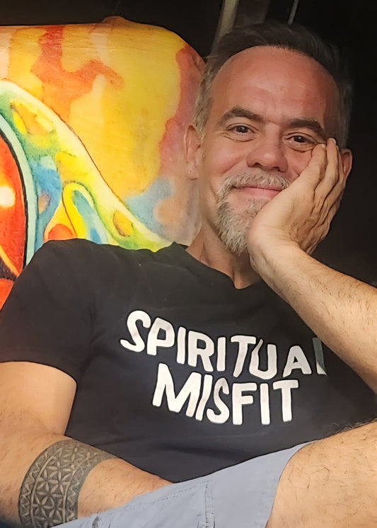 Portrait of a man in his early fifties wearing a black t-shirt, relaxed and smiling, embodying calm confidence and resilience.